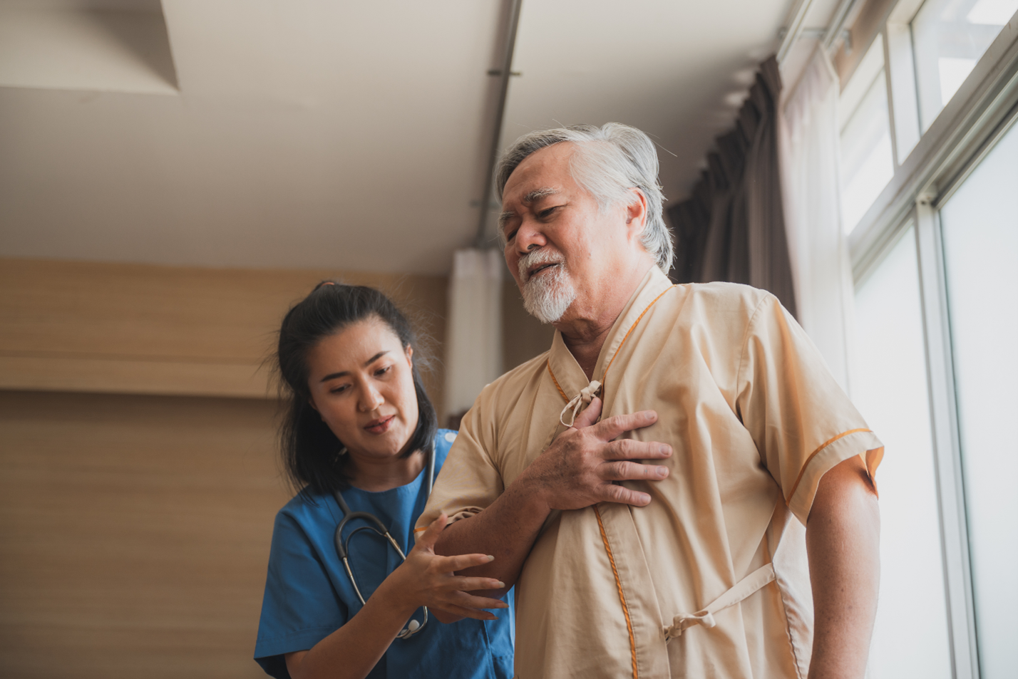 doctor helps patient in pain walk around the ER