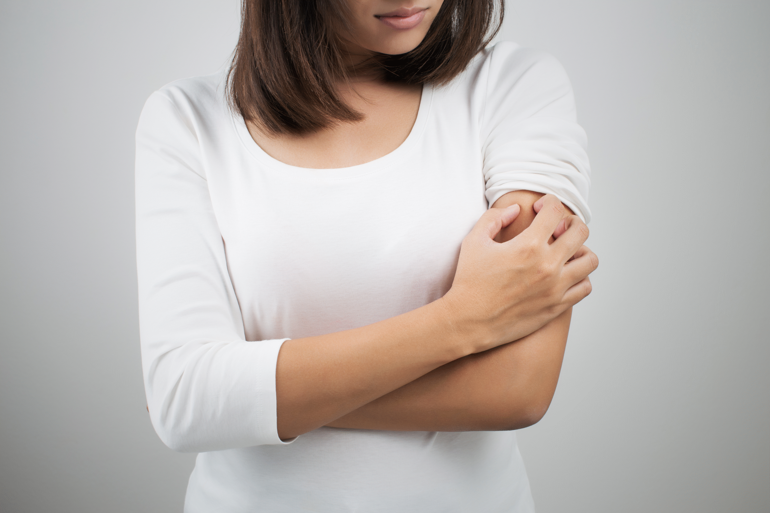 woman with itchy bug bite scratching